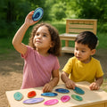 Two children playing with colorful ceramic plates outdoors.