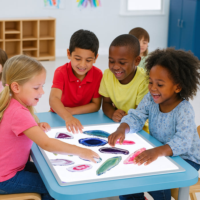 Children playing with colorful agate slices on a light table in a classroom setting.
