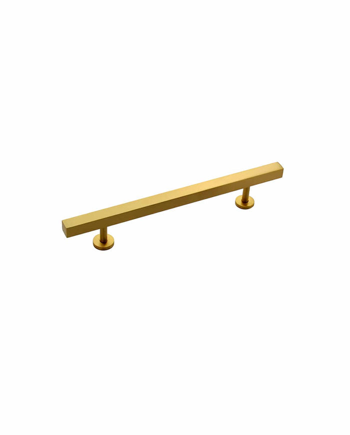 A modern, gold-colored solid brass cabinet pull by Prima Decorative Hardware features a minimalist rectangular design with two round mounting bases, isolated on a white background.