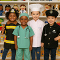 Four children in classroom setting dressed in career outfits