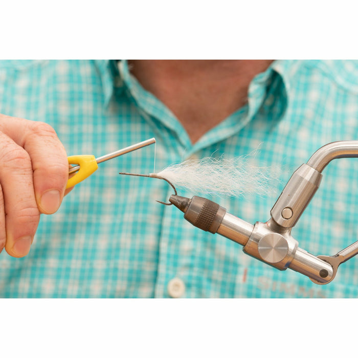 Securing white synthetic fiber onto hook with yellow tool