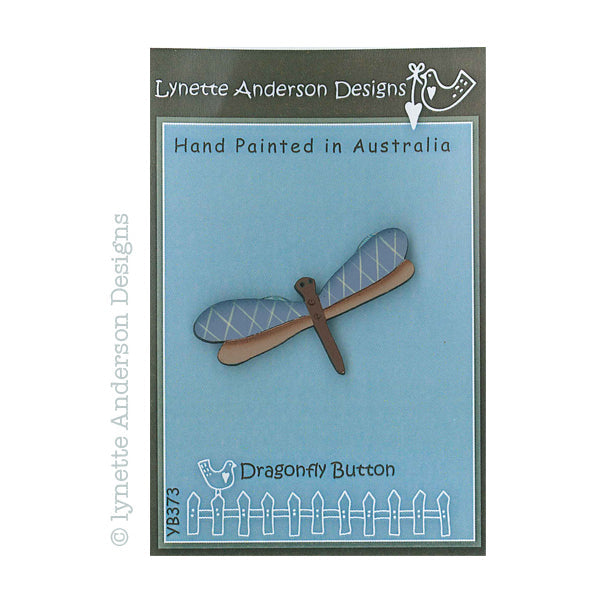 A hand painted wooden button with a blue and natural wood color scheme, labeled 'Lynette Anderson Designs' and 'Dragonfly Button'.