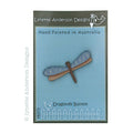A hand painted wooden button with a blue and natural wood color scheme, labeled 'Lynette Anderson Designs' and 'Dragonfly Button'.