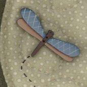 A hand painted wooden button with a blue and natural wood color scheme, labeled 'Lynette Anderson Designs' and 'Dragonfly Button'.