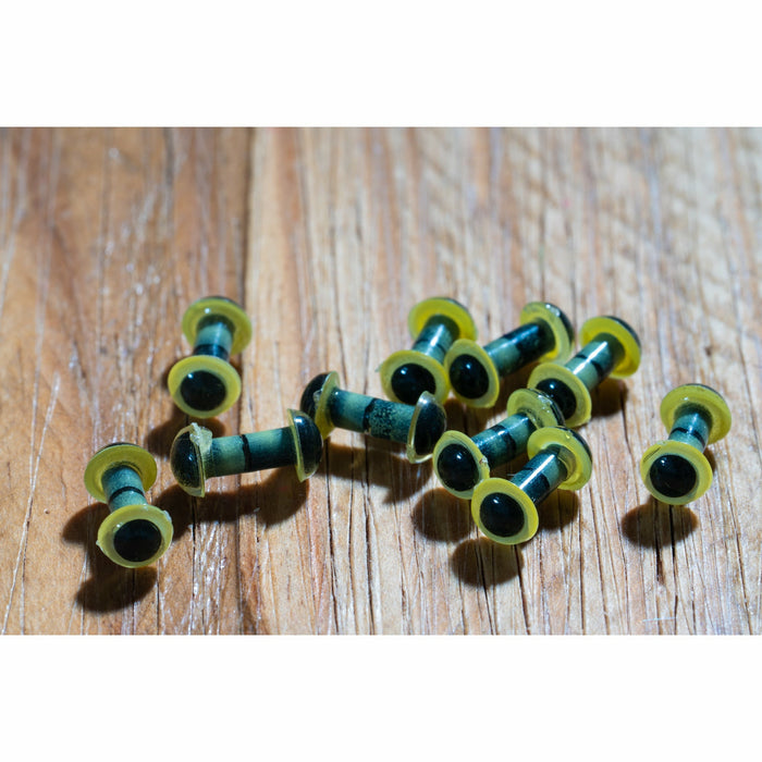 Yellow pearl figure 8 fly tying eyes with black pupils on wood