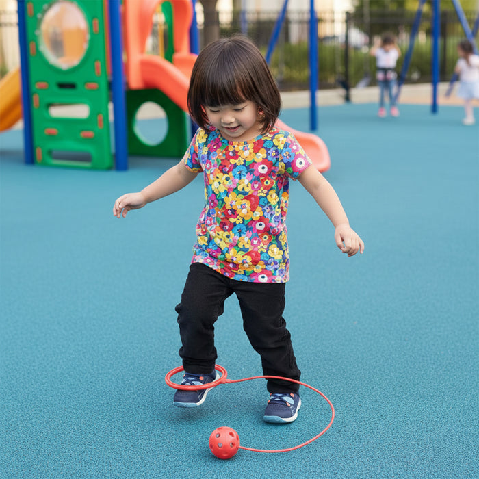 Child playing with a red ball on a playground