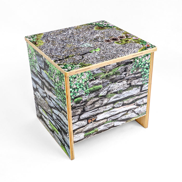 Cube-shaped bench with nature-themed design on a white background