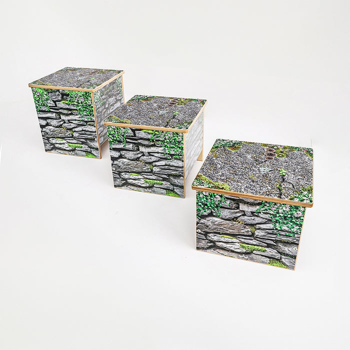 Three wooden benches in varying sizes with stone wall design on a white background