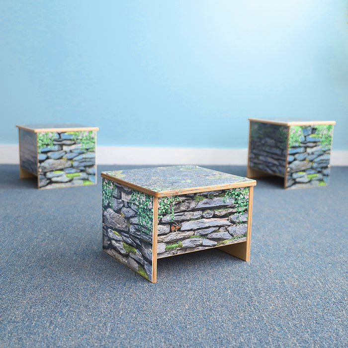 Three wooden benches with stone wall design on a blue surface and light blue background