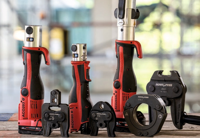 Set of red and black tools on a wooden surface with a blurred background
