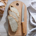 Opinel Parallele Serrated 8" Bread Knife on a cutting board with bread at Addison West