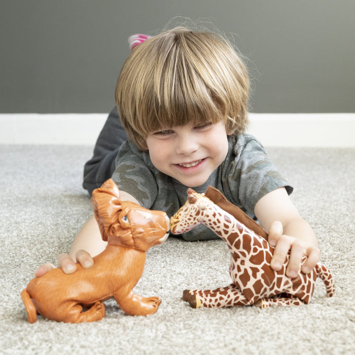 Boy on gray carpet playing with giraffe and lion animal figures