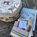 A stitching circle basket starter kit with various fabric pieces and a completed embroidered item displayed in front of the basket.