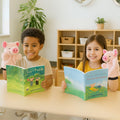 Two children sitting at a table with books and plush toys in a classroom setting.