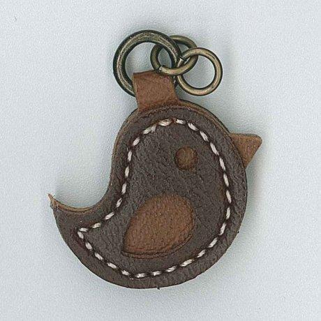 A brown vinyl zip pull in the shape of a bird with a metal ring on top.