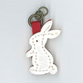 A white plastic bunny-shaped zip pull on a metal ring