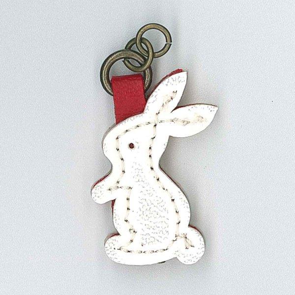 A white plastic bunny-shaped zip pull on a metal ring