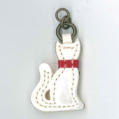 A white cat-shaped zip pull with a red collar and a metal loop at the top.